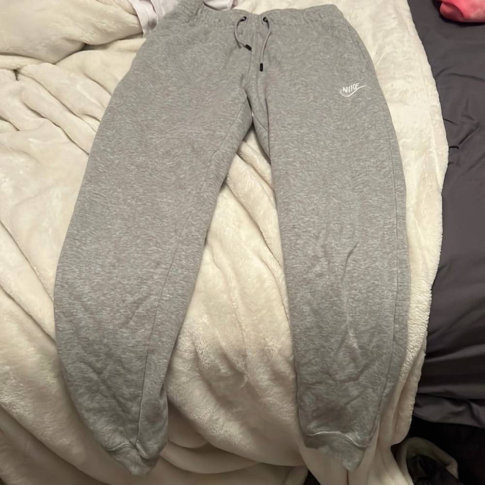 Gray Nike sweatpants cuffed at the bottom
